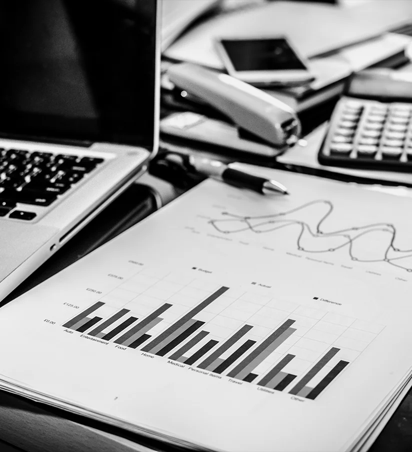 Digital marketing ROI reporting charts on a laptop and printouts in an office setting